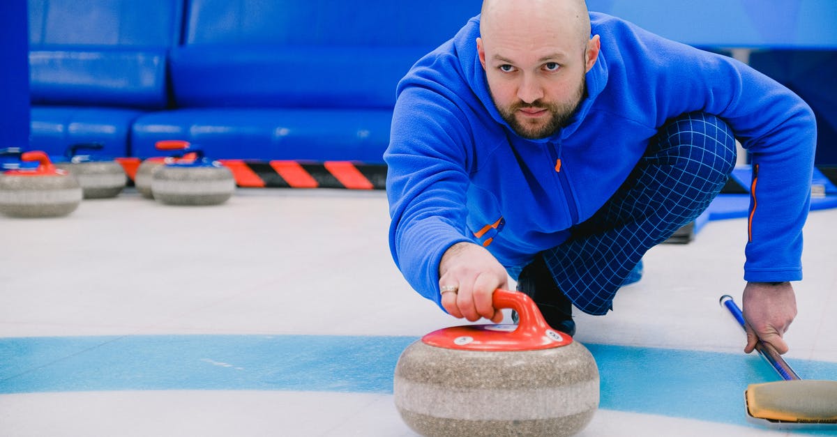 Is complimentary Wi-Fi available on ICE trains outside of Germany? - Concentrated sportsman in blue activewear squatting down and throwing heavy stone while playing curling on modern ice rink