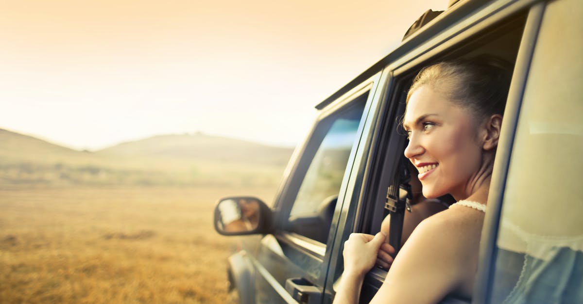 Is Guantánamo Bay, Cuba open to visitors/tourists? - Young happy female smiling and enjoying sunset through open window while traveling by car