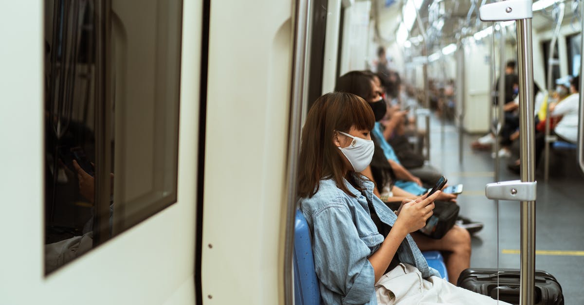 Is is possible to have numbers from 2 frequent flyer programs for 2 passengers on the same reservation? - Woman Wearing a Face Mask on the Subway