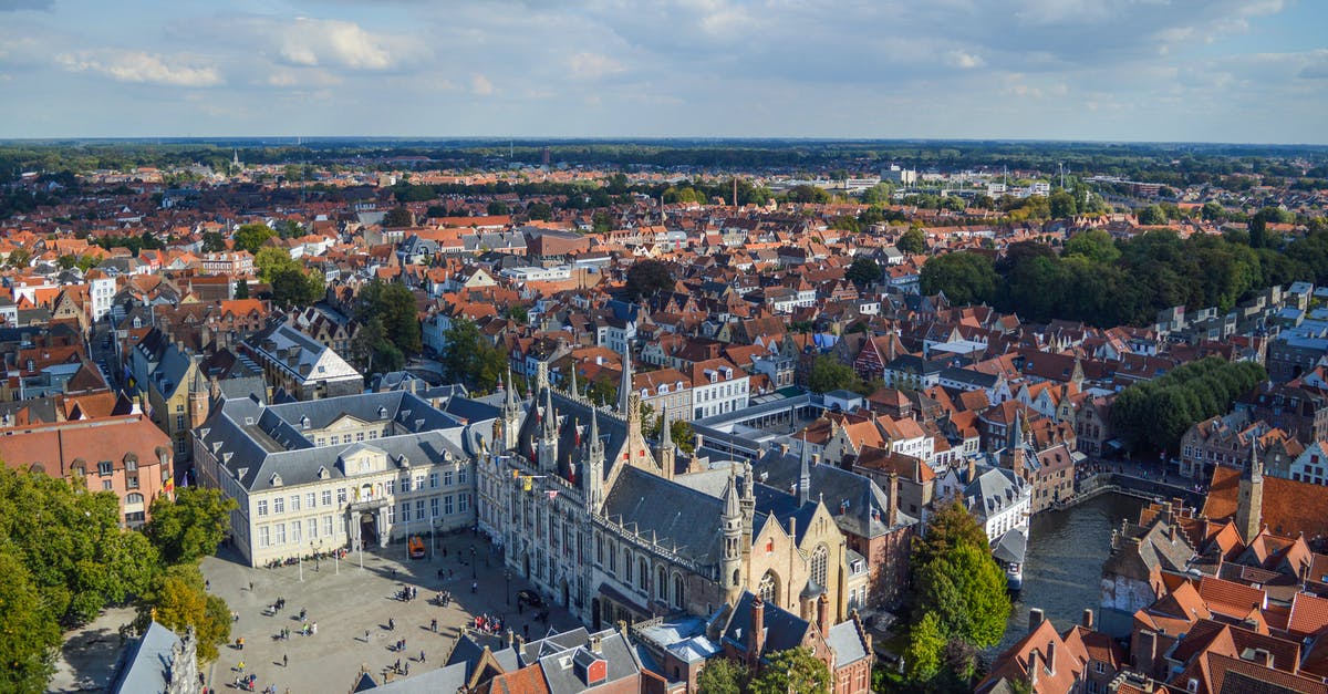 Is it a good option to visit Ghent and Bruges in the same day? - Canal flowing near old town square in sunlight