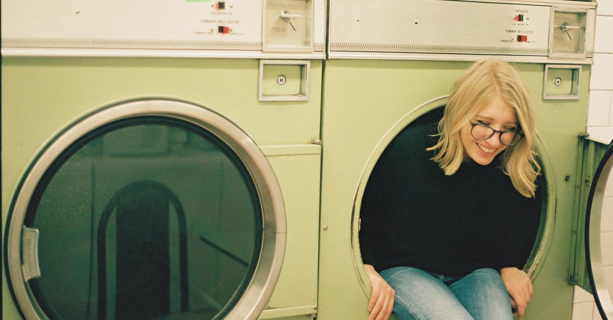 Is it a reasonable assumption that larger US hotels will have laundry facilities? - Cheerful woman sitting in laundry machine