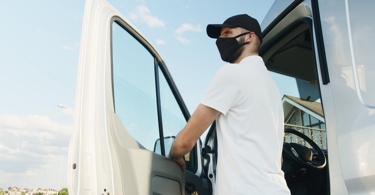 Is it normal to tip an Uber driver in Canada? - Man in White Polo Shirt Standing by the Vehicle Door