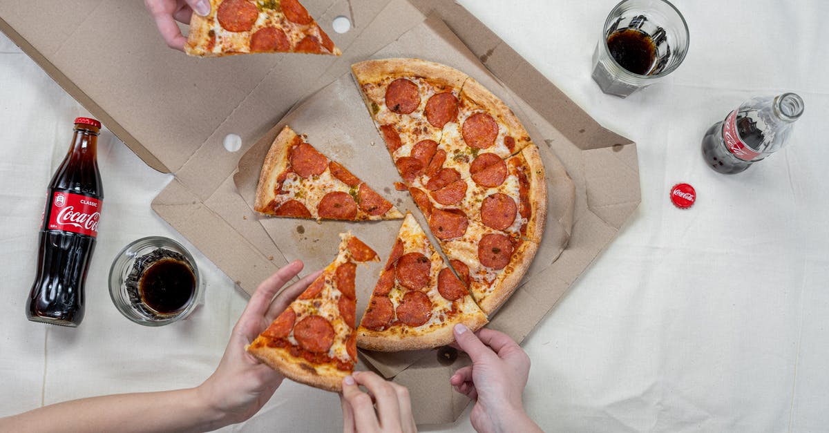 Is it not appropriate to eat pizza with hands in Germany? - Person Holding Pizza on White Box