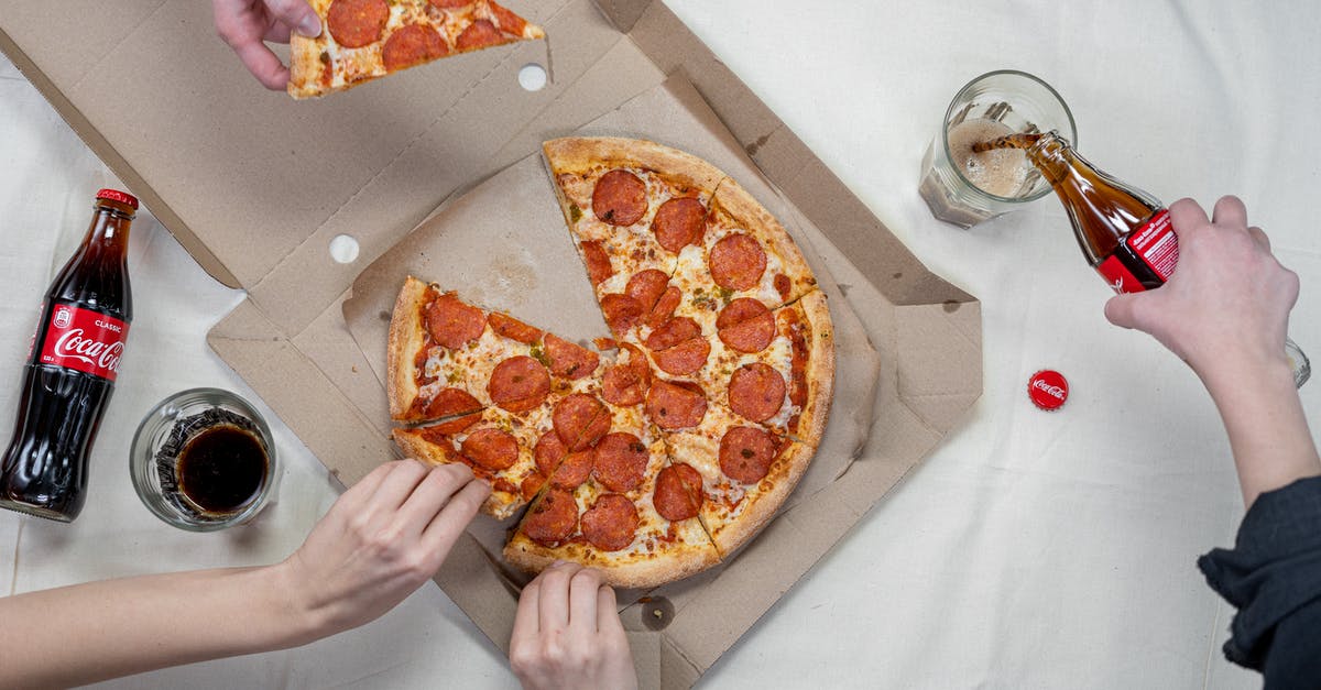 Is it not appropriate to eat pizza with hands in Germany? - Person Pouring A Drink Into A Glass