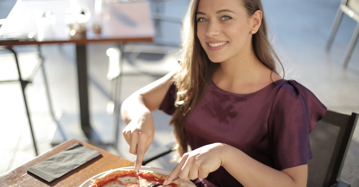 Is it not appropriate to eat pizza with hands in Germany? - Woman in Purple Top Eating Pizza