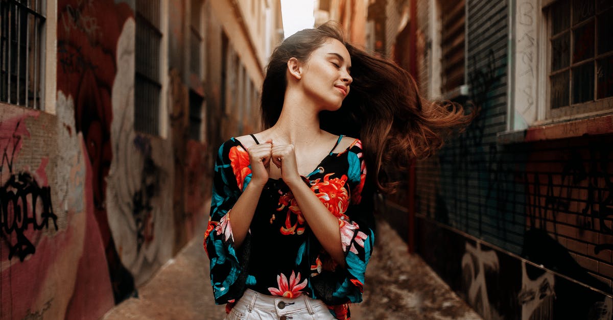 Is it okay to wear a pouch when flying? - Woman Standing in Between Buildings