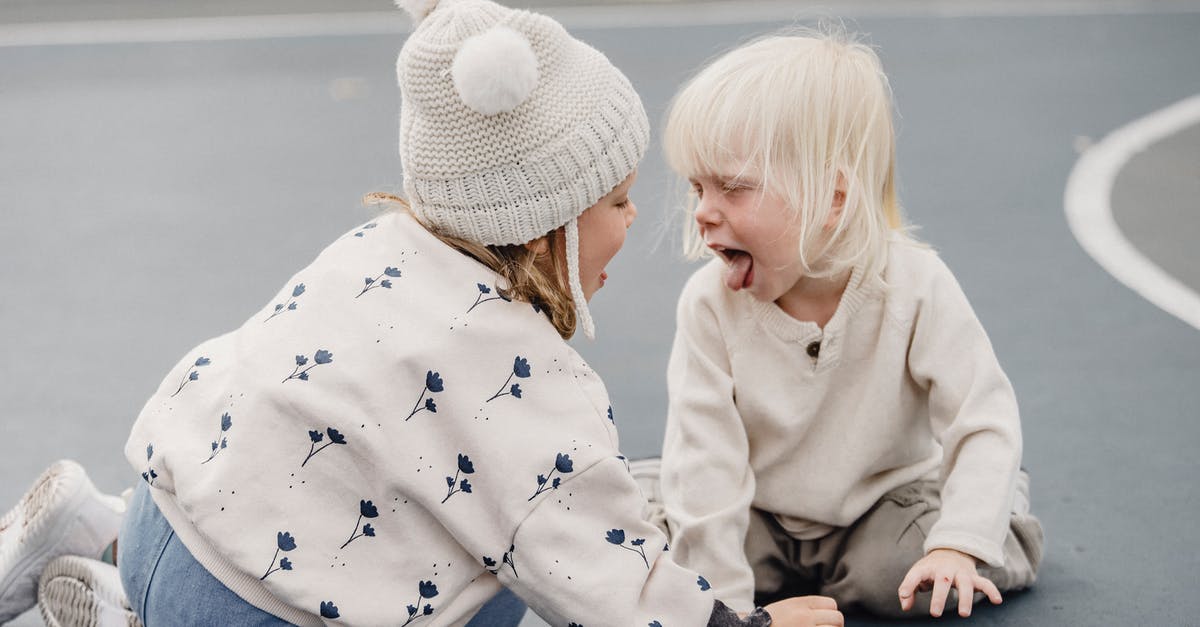 Is it possible for tourists to enter/attend Japanese Game Shows? - Side view of cute little girl with hat and playful boy showing tongue sitting on sports ground while having fun against blurred background