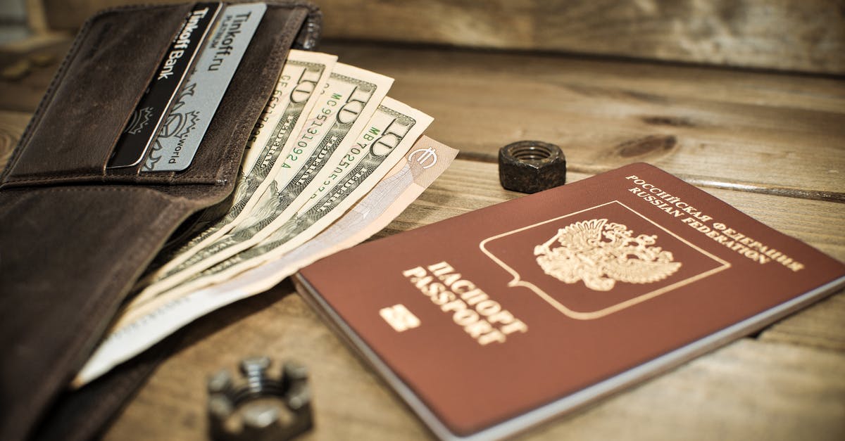 Is it possible to apply for Russian passport by mail/internet in North America? - Photo of a Brown Passport Beside a Wallet with Dollar Bills