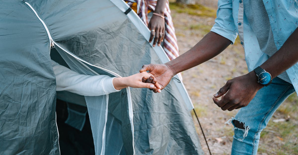 Is it possible to camp in a tent in Finland - Man in Blue T-shirt Holding Persons Hand