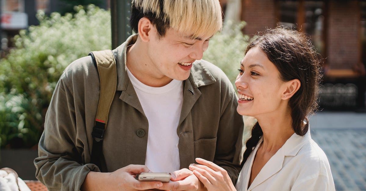 Is it possible to change date of a connection? - Positive young multiethnic couple smiling and looking at each other on street