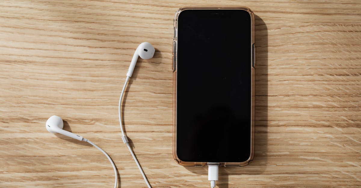 Is it possible to connect with Hainan Airlines from India/Bangladesh? - Charging smartphone and white earphones on wooden table