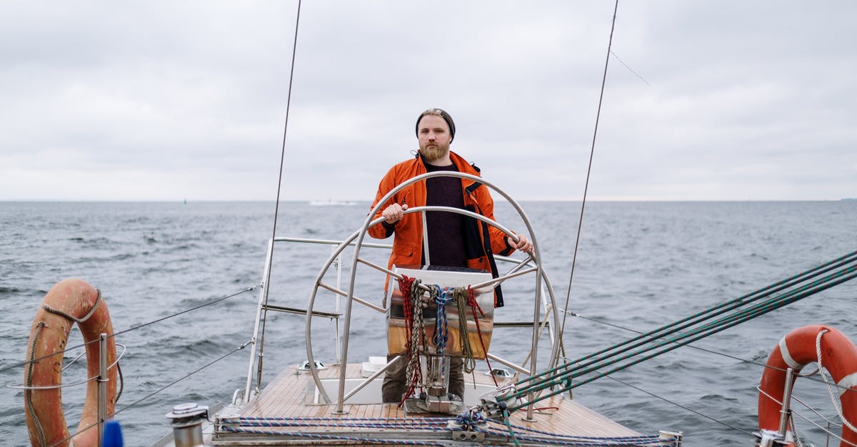 Is it possible to drive to Hawaii? - Man in Orange Jacket Sailing on a Boat