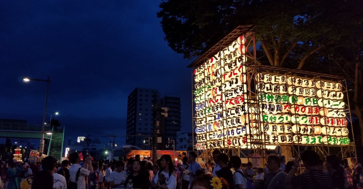 Is it possible to enter Japan for a few hours with a group travel? - Group of People Near Multicolored Lantern Display