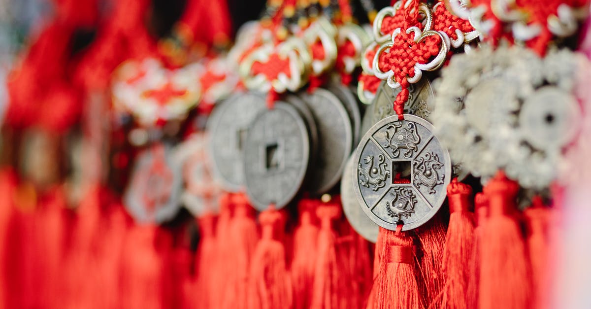 Is it possible to get a Chinese visa if you already possess a valid visa for a different purpose? - Collection of assorted round amulets in shape of Chinese coins with red satin threads