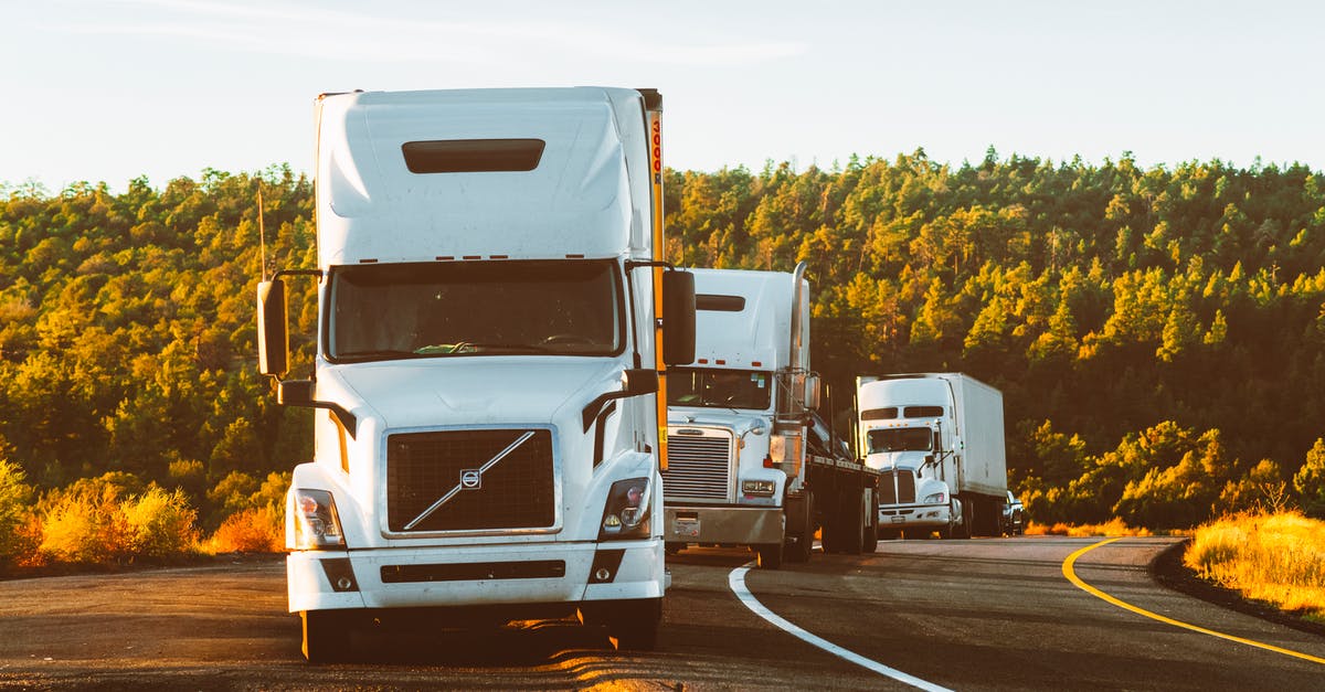 Is it possible to travel on cargo airplanes? - White Volvo Semi-truck on Side of Road