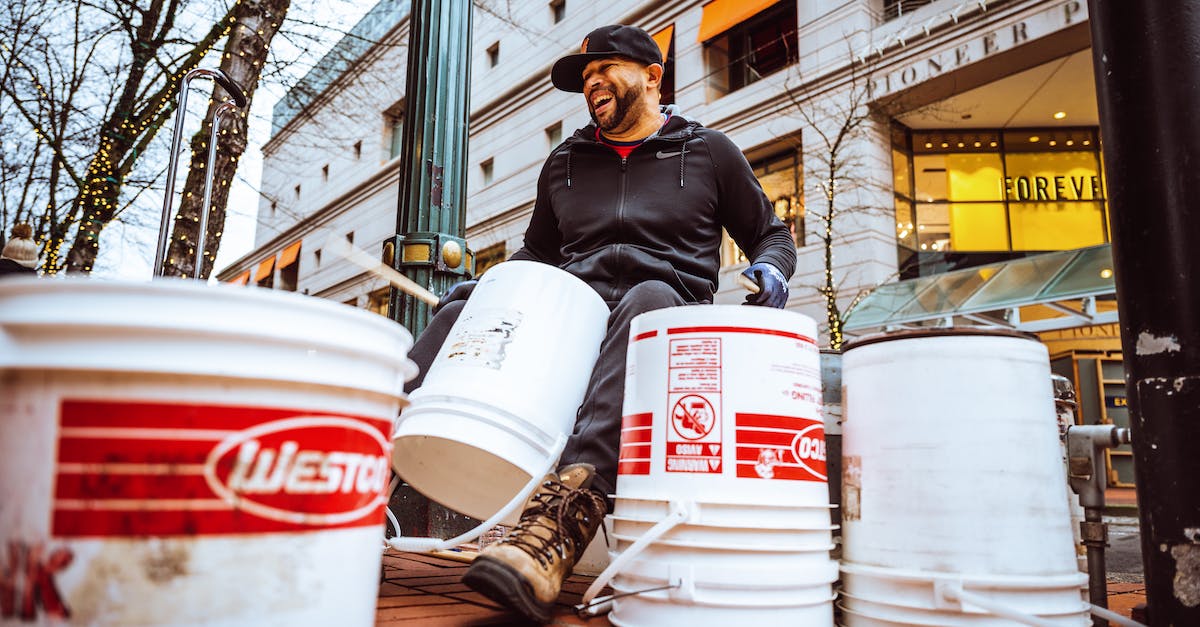 Is it practical to live in Stockholm's inner city while studying in Kista? [closed] - Joyful creative ethnic busker using buckets during performance on city street