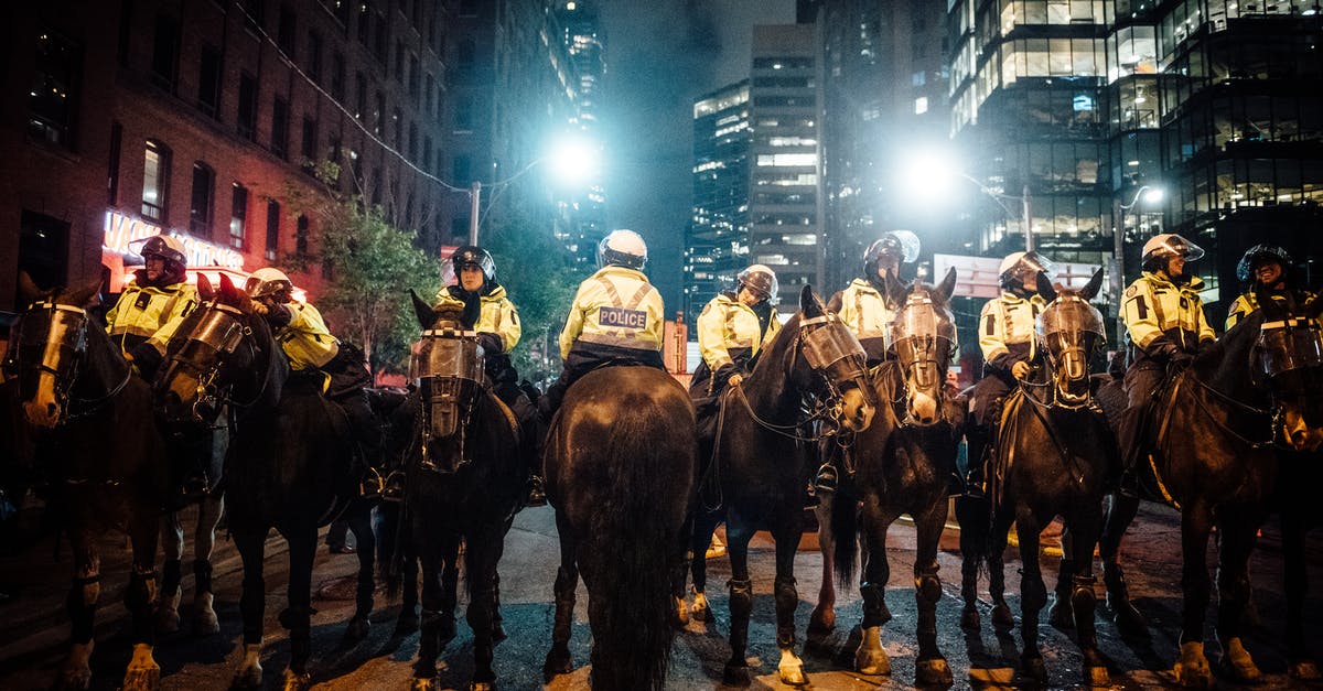 Is it risky to wear a name tag in public in an unfamiliar city? - Group of Policemen on Horse