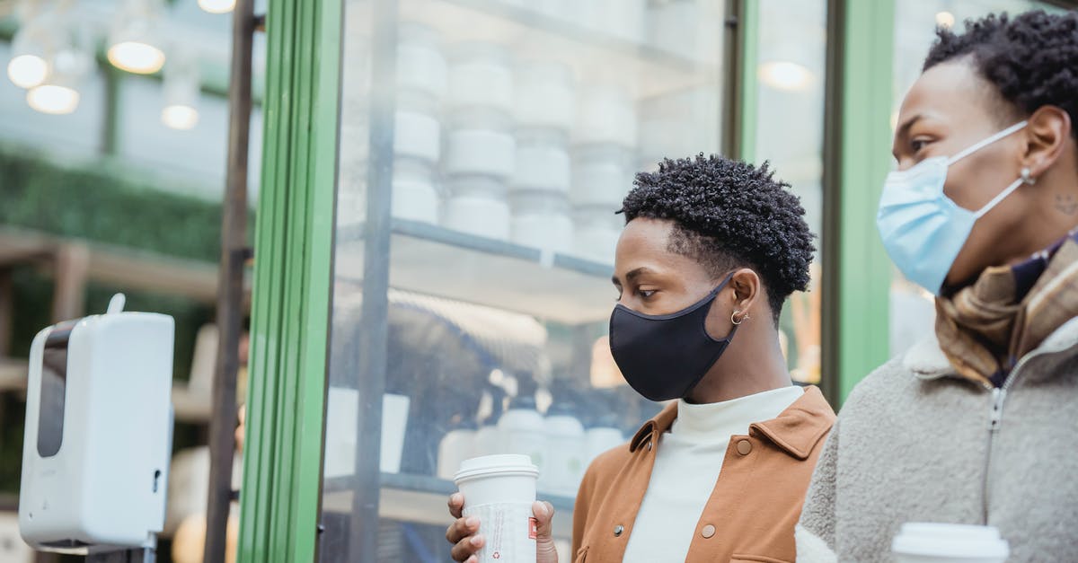 Is it safe to go to Içmeler, Turkey now? - African American male couple with tasty takeaway hot beverages strolling on street near building while spending time together in city