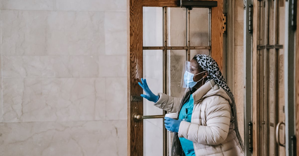 Is it safe to leave baggage in budget hotels Rome? [closed] - Black nurse in respirator and gloves leaving modern building