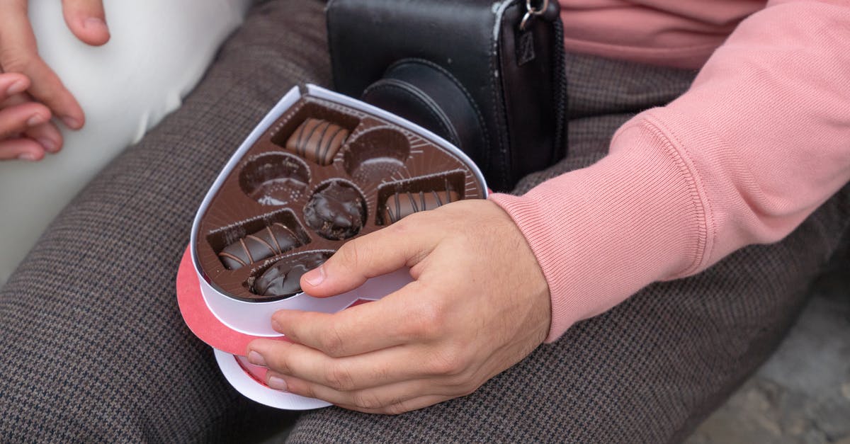 Is it safe to roam with girlfriend in India on February 14? [closed] - Anonymous man with box of chocolates sitting on street with girlfriend