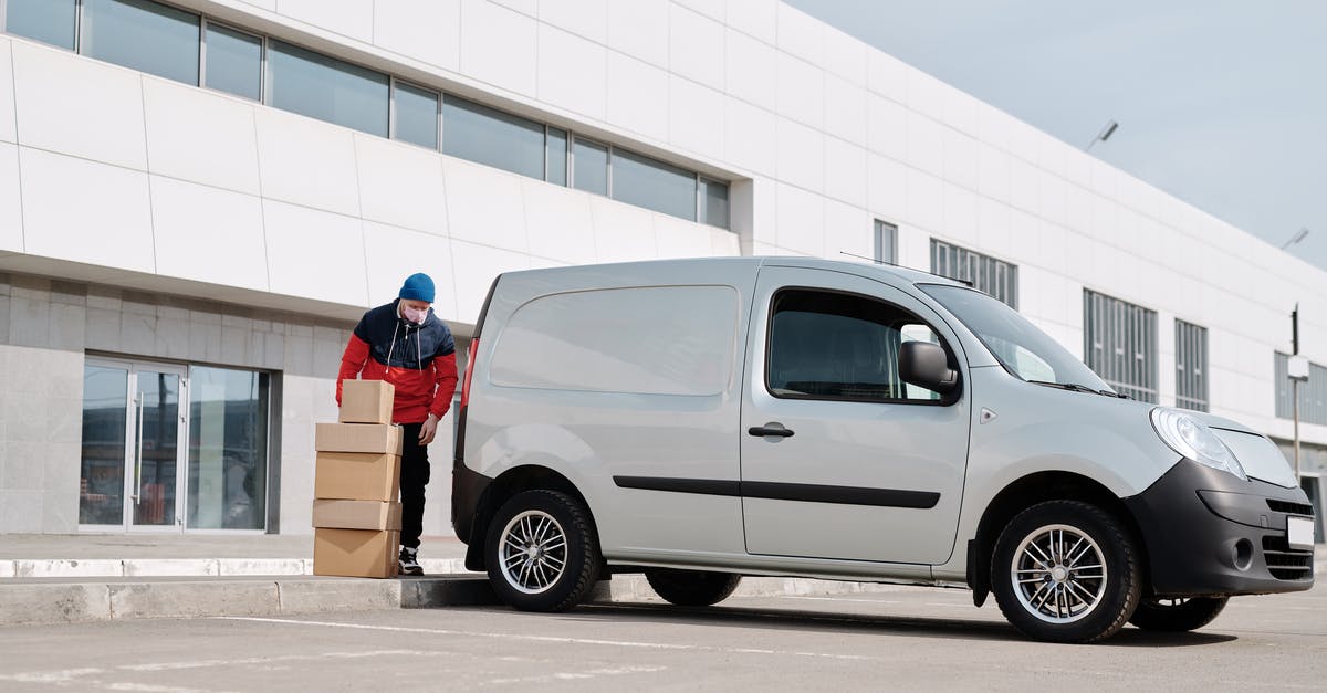 Is it safe to stay outside the Boulevard Périphérique in Paris? - Delivery Man With Boxes next to a White Van