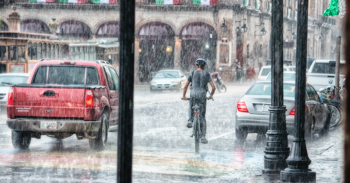 Is it safe to travel by bike between cities in Spain? - Person Riding a Bicycle during Rainy Day