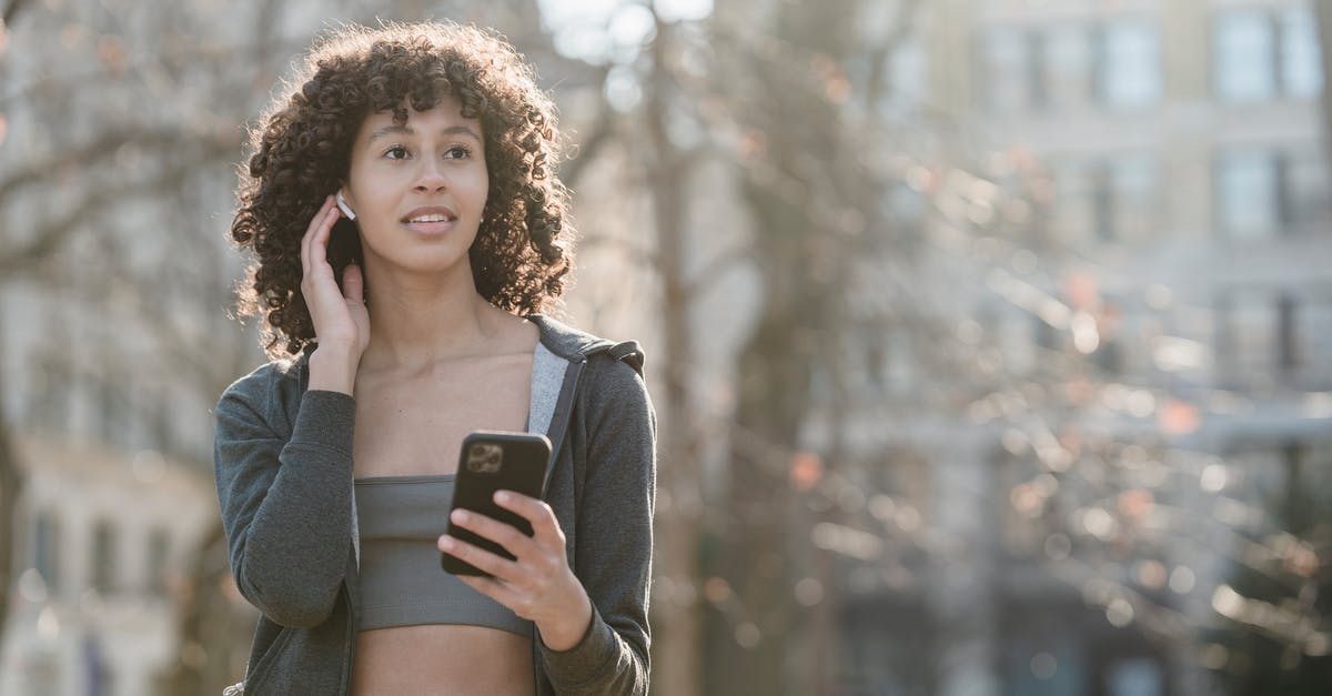 Is it true that Australia no longer issues physical visa stickers? - Ethnic sportswoman connecting earbuds with smartphone