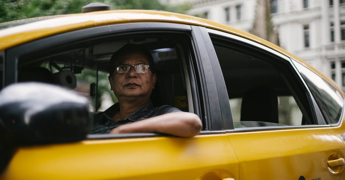 Is MARTA a good option to commute to/through downtown Atlanta? - Through window of male driver in glasses sitting in cab while driving in downtown of city and looking away