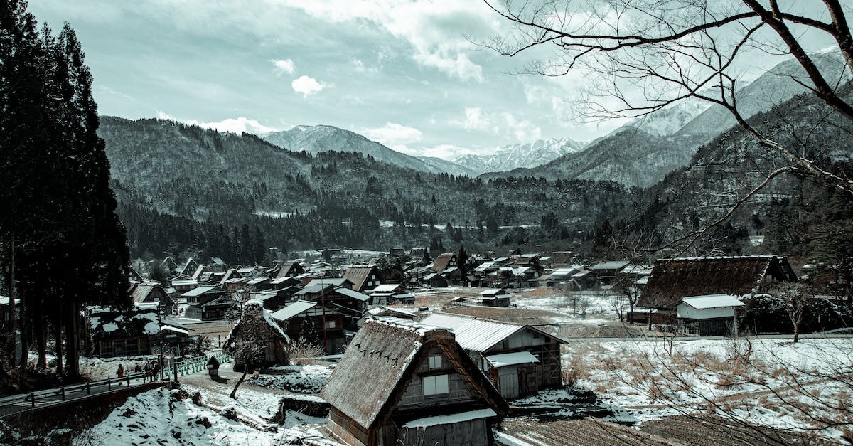 Is Mount Pilatus worth visiting in winter? - Village with houses near mountains in winter under cloudy sky