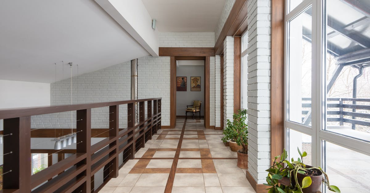 Is my ESTA valid for a second trip? - Long corridor with wooden railing and potted green flowers placed near bid windows located on second floor of contemporary house