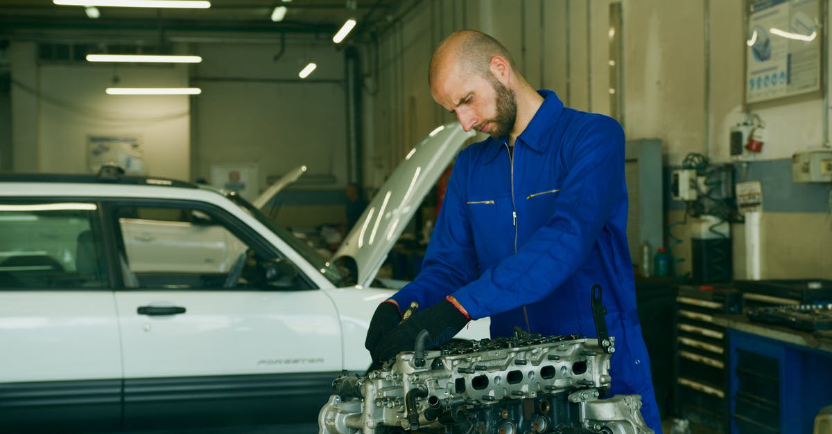 Is not checking in any baggage suspicious? - A Man in Blue Uniform Repairing an Engine