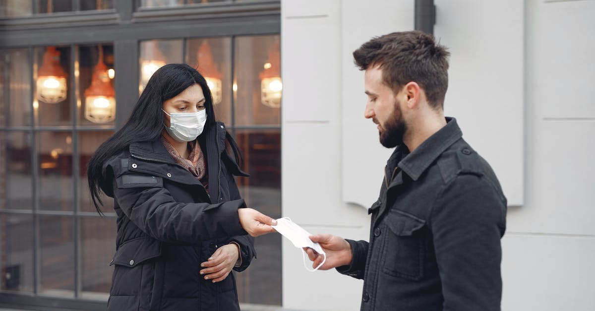 Is refund possible if I cannot take a (just rebooked) flight because of coronavirus bans? [duplicate] - Young couple with medical masks on city street during cold season