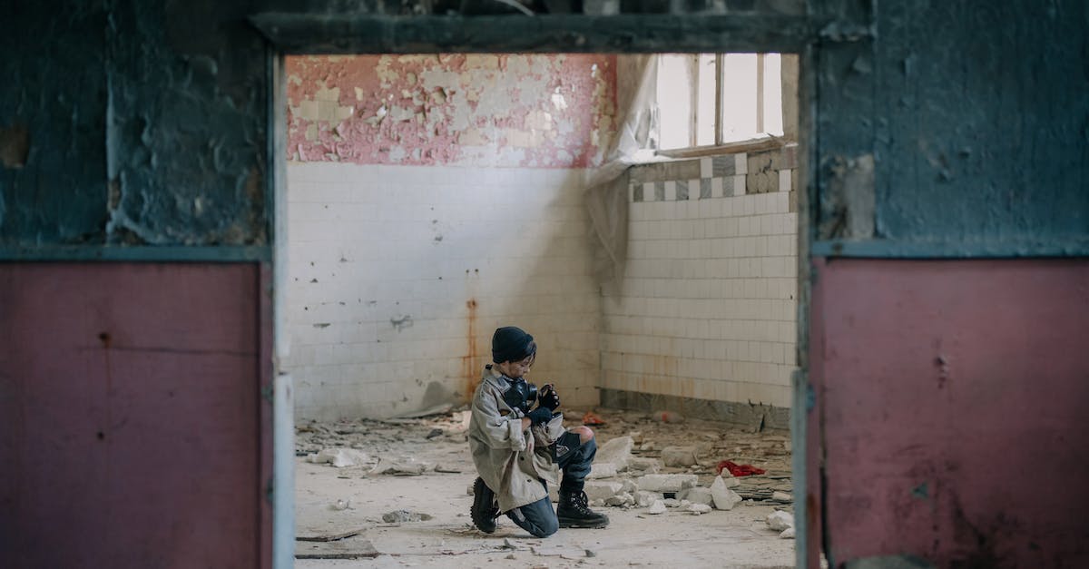 Is squatting a viable alternative for accommodation? - Man in Black Jacket Sitting on Floor