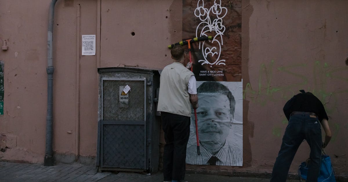 Is standing actually illegal in Venice? - A Person Putting Poster on the Wall