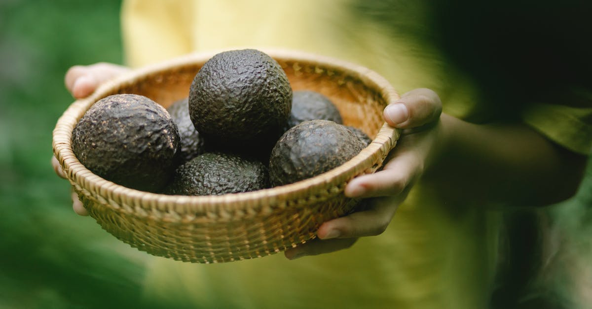 Is Sweden full of mosquitoes during the summer? - Crop faceless female holding wicker bowl full of avocado while standing in garden