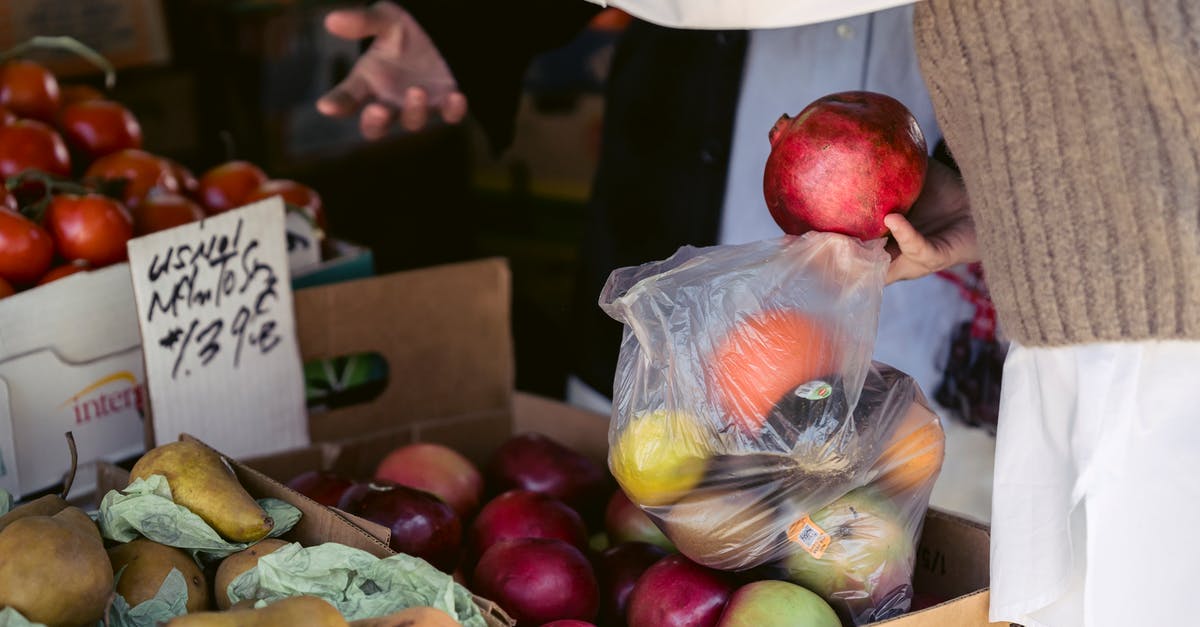 Is the Apple SIM pricing comparable to buying a local sim-card? - Crop woman choosing assorted healthy fruits in street market