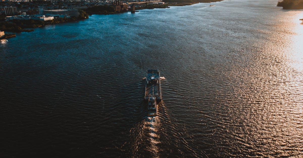 Is the Buffalo River at King Williams Town navigable by boat? - Drone view of ship floating on rippling water surface in sunny day and moving towards coastal city