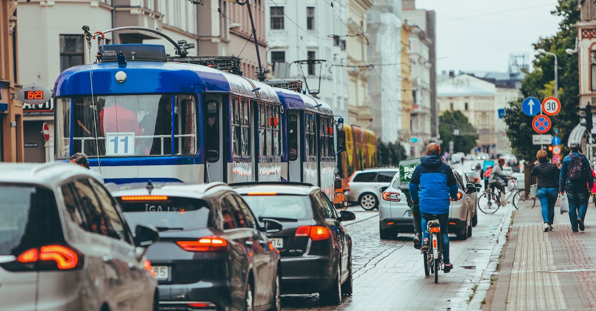 Is the Dunkirk area suitable for bicycling? - Modern vehicles driving slowly with riding cyclist on busy road in city while people walking and sidewalk near old buildings