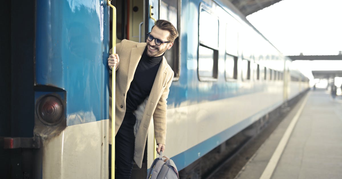 Is the Koboro rail station really inaccessible by land? - Man Wearing Beige Overcoat Inside Train