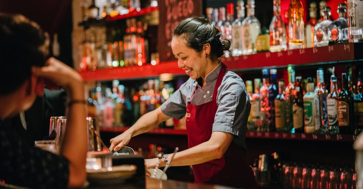 Is The Mileage Club a legitimate business? - Woman Bartender Smiling While Mixing Liqueurs