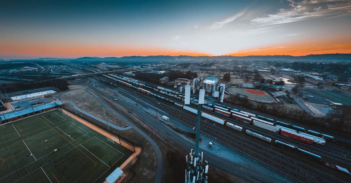 Is the Polish railway system very fragmented? - Aerial view of industrial district of Chattanooga city with green rugby fields and modern cell tower located near railroad tracks against sunset sky