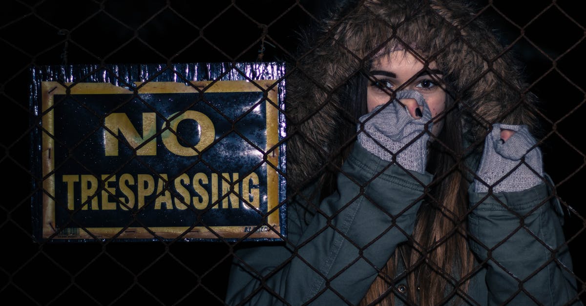 Is the sign of horns offensive in Australia? - Woman Behind Black Chainlink Fence With No Trespassing Signage