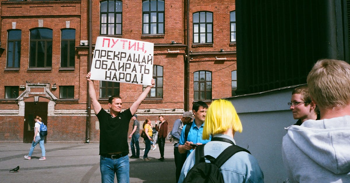 Is the sign of horns offensive in Australia? - Man Standing Outdoor While Holding Signage