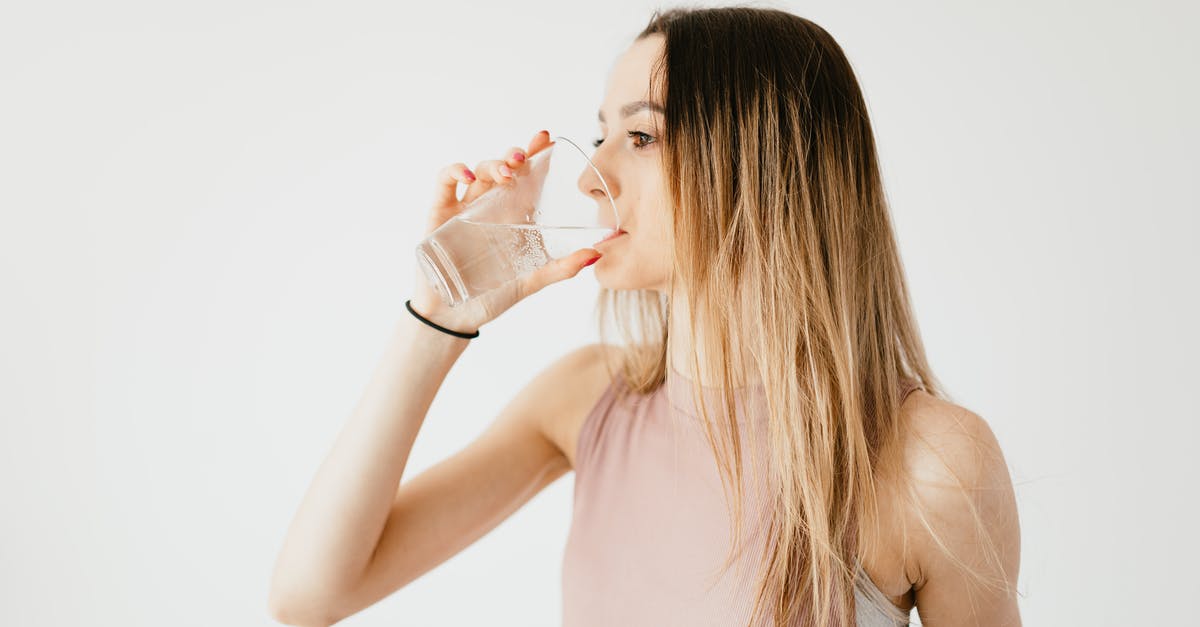 Is the tapwater fit to drink throughout Taiwan? - Young thirsty fit female with long hair in sportswear drinking water while recreating after workout