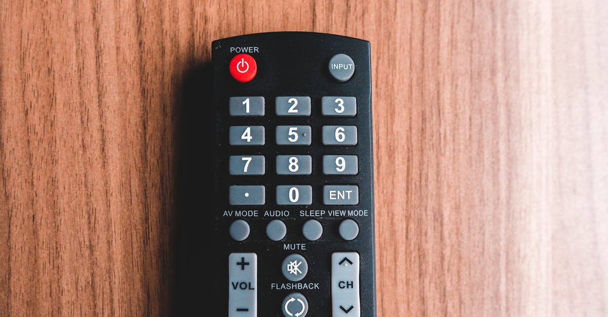 Is the word “bomb” muted in in-flight movies? - Top view of plastic remote control with rows of buttons representing power and mute symbols on brown background