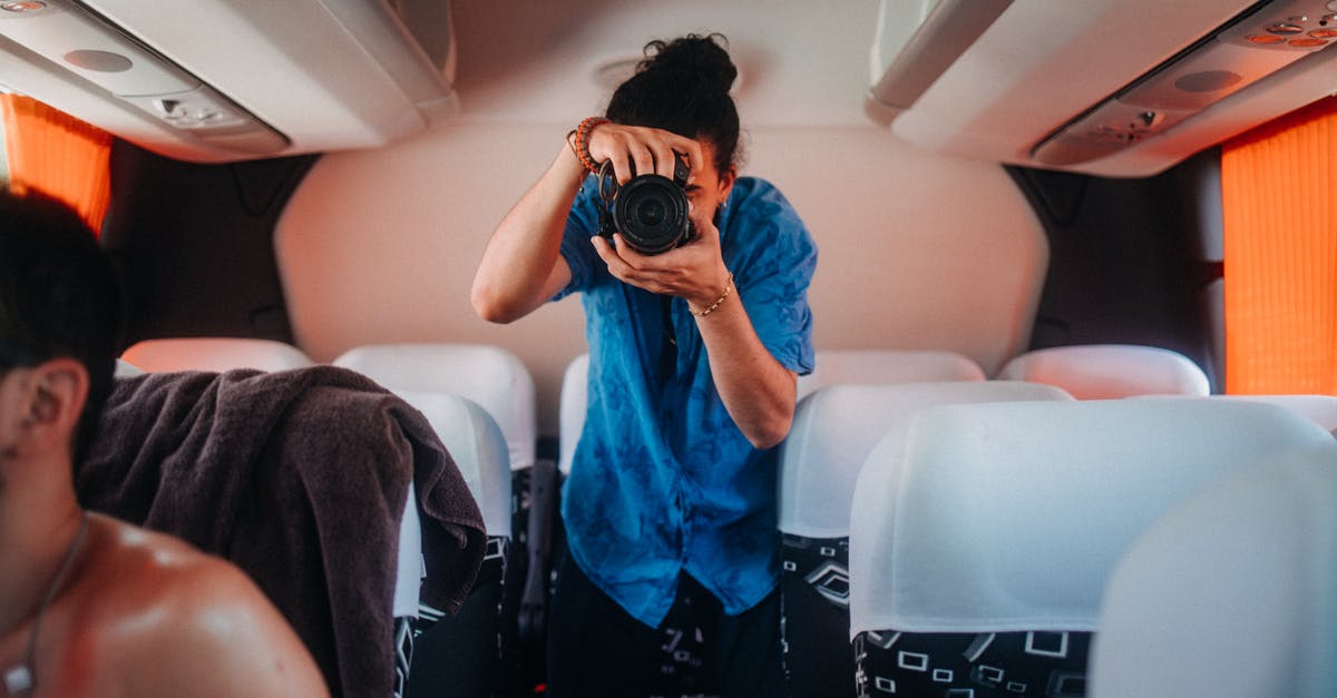 Is there a bus pass for Eastern Canada? - Woman in Blue Shirt Holding Black Camera