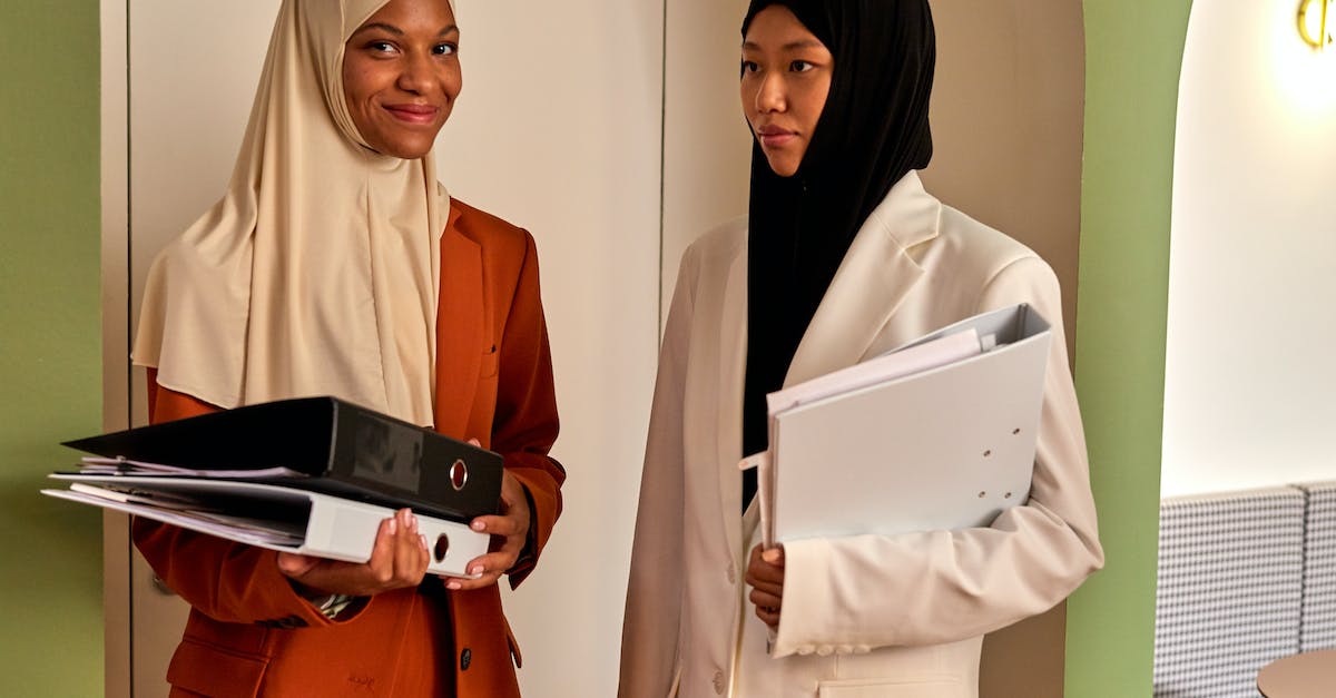 Is there a dress code when visiting the Vatican in Rome? - Muslim Women in Hijabs Standing in Office Interior