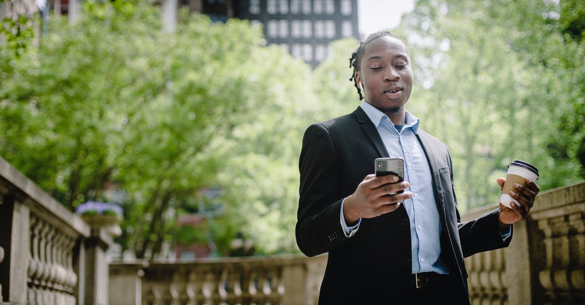 Is there a good and objective resource online about Zika virus? - Positive young black man with smartphone and takeaway coffee in city park