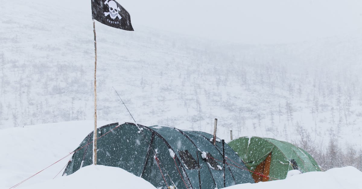 Is there a list of hiking shelters in Quebec? - Colorful tents of expedition with flag with skull placed on ground in highland in snowstorm