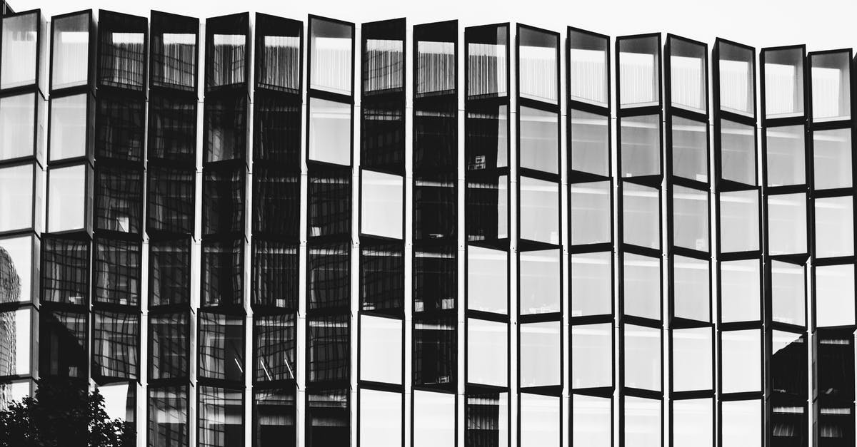 Is there a possibility the company can block my b1/b2 visa? - Black and white of high contemporary multi storey office construction with same transparent windows